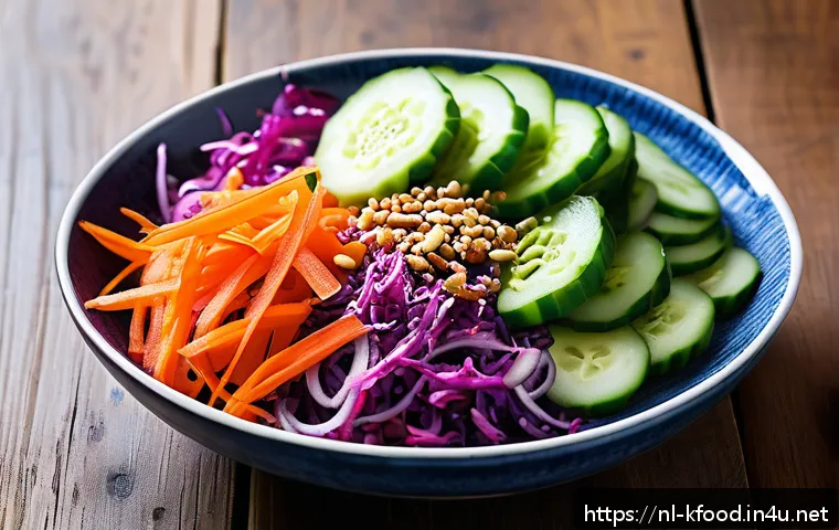 한식 샐러드 레시피 - A vibrant Korean-inspired salad bowl featuring thinly sliced fresh Dutch cucumbers, shredded carrots...